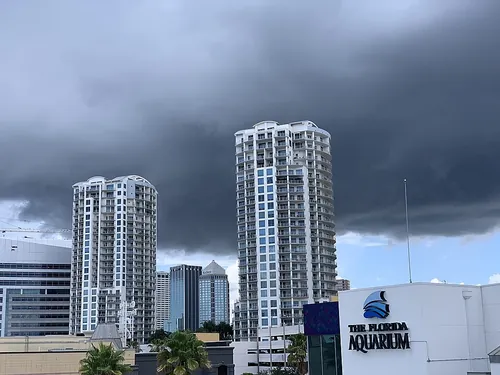 高層ビルの上空を覆う暗い雨雲